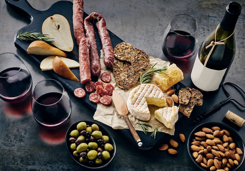 Charcuterie-board-with-bottles-and-glasses-filled-with-wine.-